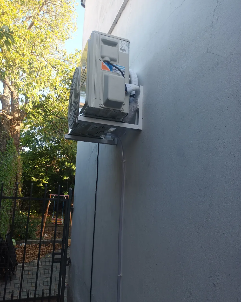 Unidad exterior de un aire split instalada por SIK Refrigeración en la pared de una casa